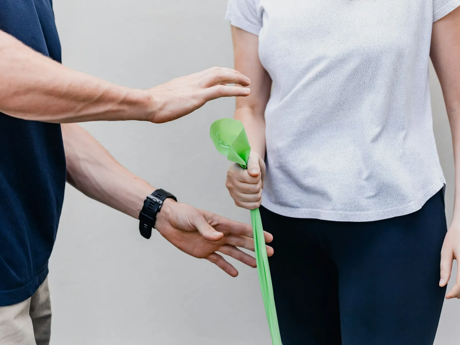 Patientin trainiert mit einem Therapieband unter Anleitung