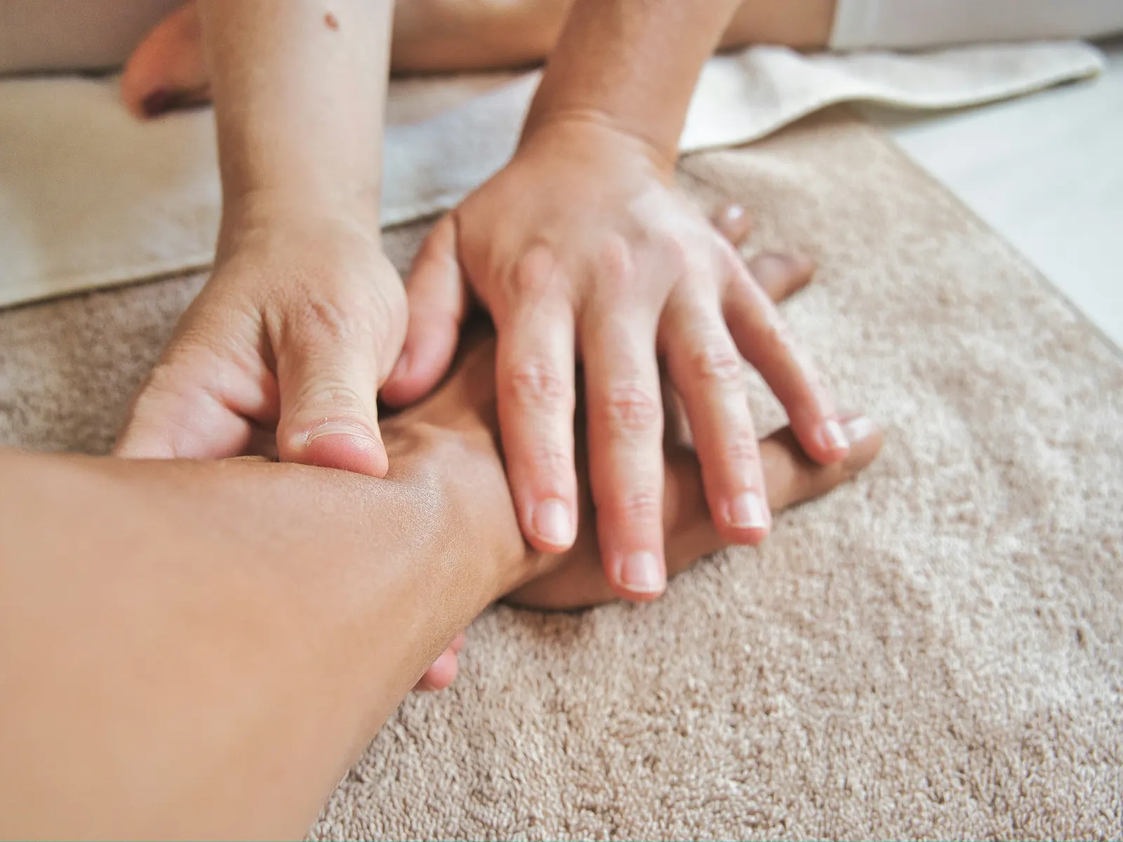 Shiatsu: Druck mit den Fingern entlang der Meridiane auf der Bodenmatte
